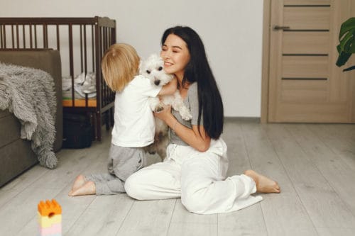 Mãe e criança brincando com o cachorro