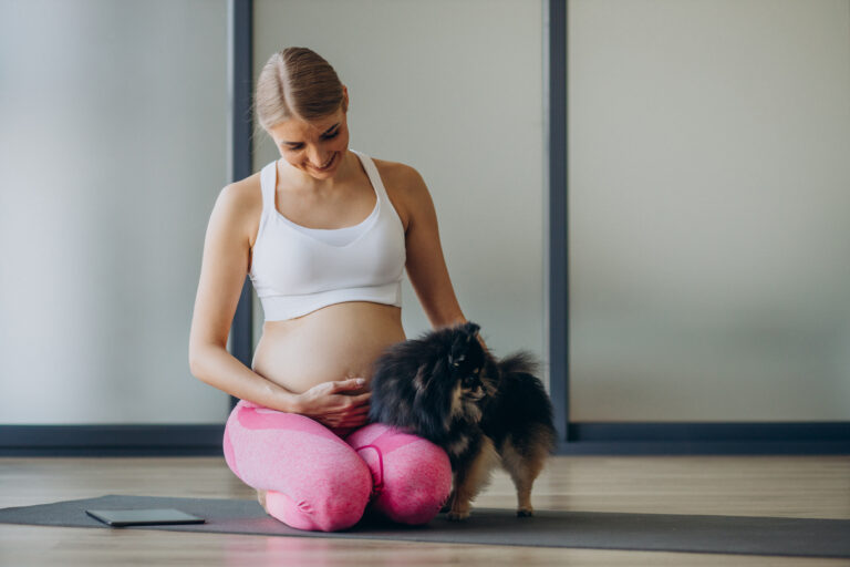 mulher gravida praticando ioga com seu cachorro de estimacao